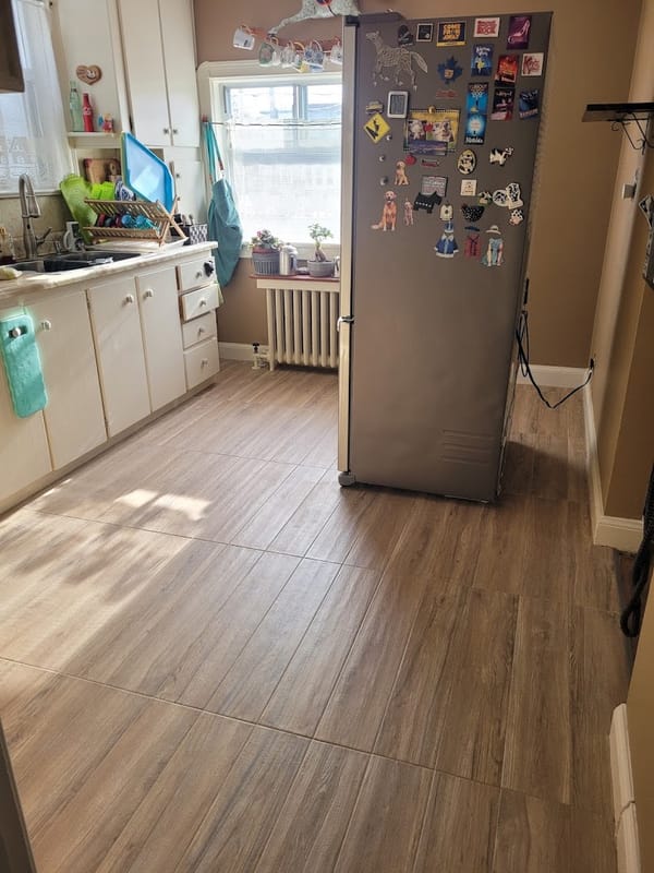 Same kitchen after renovation with new wood-look flooring